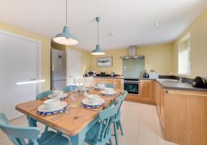 AldringhamWest Barn Cottage的厨房配有木桌和蓝色椅子
