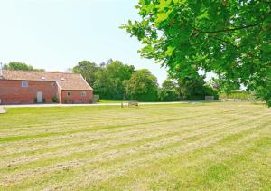 AldringhamWest Barn Cottage的一座带谷仓和建筑的大型草地