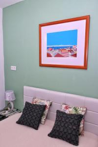 里斯本Lisbon apartment的粉红色的床、枕头和墙上的照片