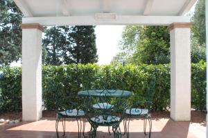 努马纳Casa Bianca Stella的天井设有桌子和四把椅子。