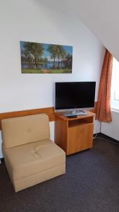 佩尔赫日莫夫Motel Velký Rybník的一间带电视和椅子的客厅