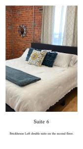 MartinsvilleBrickhouse Loft - a boutique hotel的一张带白色床单和蓝色枕头的床