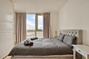 伦敦Delightful Apartment Wandsworth的一间卧室设有一张大床和大窗户