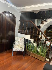 南卡希亚斯HOSTEL FAMILIA ZANATTA的一间带椅子和楼梯的客厅