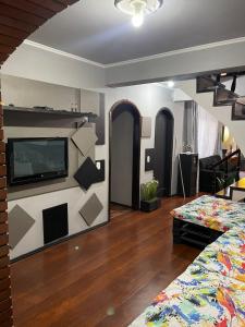 南卡希亚斯HOSTEL FAMILIA ZANATTA的一间设有床铺和墙上电视的房间