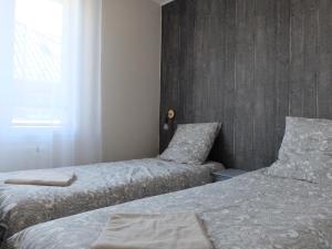 圣热尔韦莱班Thermalines的一间卧室设有两张床和窗户。