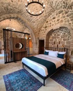 马尔丁TUĞMANER Small House AJAR的一间卧室设有一张大床和石墙