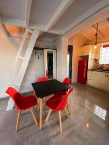 VagiaNikoli House的一间用餐室,配有黑桌子和红色椅子