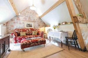 勒德洛The Hayloft, Pillar Box Farm Cottages的客厅配有红色的沙发和桌子