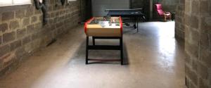 蒂龙加尔代GITE Thiron Gardais LA COUR aux PAUVRES的砖房里的乒乓球桌和乒乓球桌