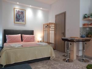 埃尔莫波利斯Nisos suite的一间卧室配有一张床、一张桌子和一张书桌