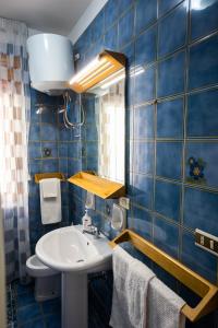 斯卡莱阿Gilda’s Home的蓝色瓷砖浴室设有水槽和镜子
