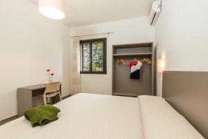 包内伊Il Rifugio的一间卧室配有一张床、一张书桌和一个窗户。