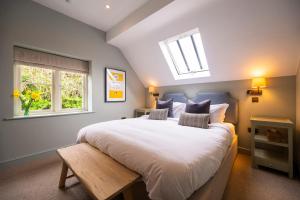 亨利昂泰晤士The Bottle & Glass Inn - Garden View - Room 1的卧室配有一张白色大床和天窗