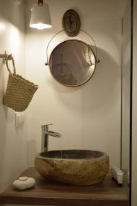 ZefiríaHemeros Villa的一间带石制水槽和镜子的浴室