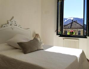 圣费德勒·因特尔维Hotel Villa San Fedele的卧室配有白色的床和窗户