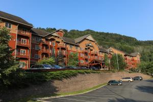 亨特Kaatskill Mountain Club and Condos by Hunter Mountain的停车场内一排公寓楼,有车辆停放