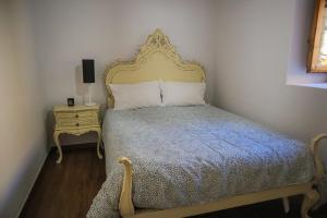 科维良Primor Serra AL的一间卧室配有一张带金色床头板和桌子的床