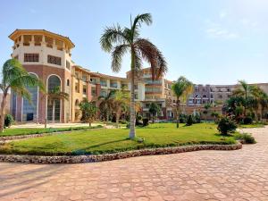 赫尔格达Royal Beach Private Apartments Hurghada的一座棕榈树环绕的大建筑