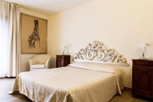 皮耶韦迪索利戈利诺宾馆的卧室配有白色的床和椅子