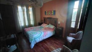富内斯Casa Funes的一间卧室配有一张床、一把椅子和窗户。