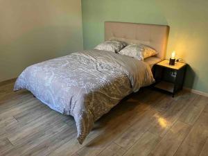 内拉克Maison avec charme的一间卧室配有一张床和一个带灯的床头柜