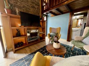 蓬塔杜帕戈Victoria Tiny Stone House的带沙发和电视的客厅