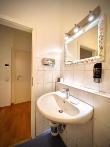 纽伦堡托库斯旅馆的浴室设有白色水槽和镜子