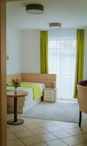 纽伦堡托库斯旅馆的一间卧室配有一张带绿色窗帘的床和一张桌子