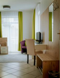 纽伦堡托库斯旅馆的客厅配有椅子和书桌及电视