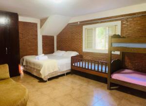 阿纳波利斯Refúgio do Cerrado的一间卧室设有两张床、一个窗口和一张沙发