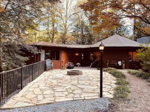 加特林堡Cabin with Treehouse Views, 3 King Beds, 4 Bunks, and Large Hot Tub!的房屋设有带火坑和围栏的庭院