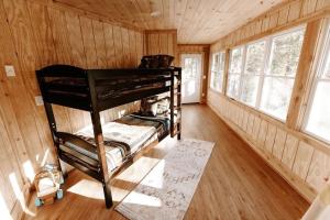 加特林堡Cabin with Treehouse Views, 3 King Beds, 4 Bunks, and Large Hot Tub!的小屋内带双层床的房间