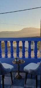 舍夫沙万IDGA appartement with panoramic view的一张带两把椅子的蓝色桌子和一张桌子上的碗