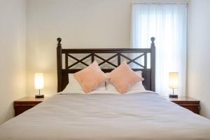 罗利Charming DT 3-Bed Bungalow with Fenced-in Yard的一张带两个枕头的床和两盏灯