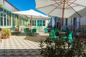 皮奇勒姆Bichon La Casa Hostal的一个带桌椅和遮阳伞的户外庭院。