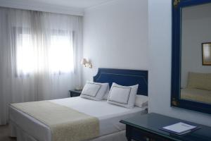 萨阿拉德洛斯阿图内斯霍斯佩德里亚多纳罗拉扎哈拉酒店的一间卧室配有一张带镜子的床和窗户