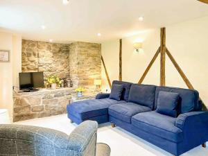 Llanfihangel-Bryn-PabuanKite 1 - Uk6549的客厅设有蓝色的沙发和石墙