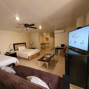 GuadalupeHotel CH的客厅配有两张床和一台平面电视