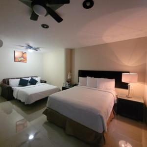 GuadalupeHotel CH的酒店客房,设有两张床和一盏灯