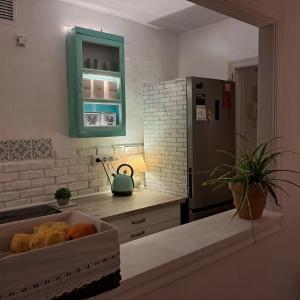 萨阿拉德洛斯阿图内斯AIRUNNES Atico duplex Zahara primera linea的厨房配有绿色橱柜和冰箱