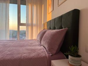 地拉那Comfy Nest Apartment- free parking的一间卧室设有一张大床和大窗户