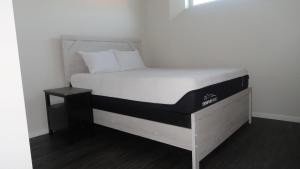 温尼伯Afan Home of Joy的一张位于带白色床垫的房间内的床铺
