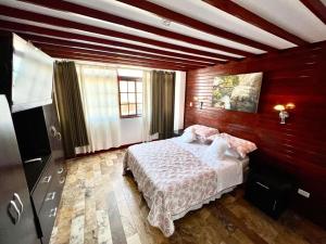 皮斯科Casa Villa Victoria en Pisco的卧室配有一张床铺,位于带木墙的房间内