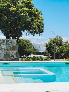 埃尔帕索Bungalow Los Laureles的蓝色的游泳池,后面有树