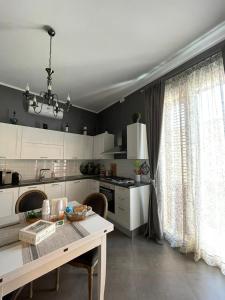 巴勒莫La Baronessa的厨房配有白色橱柜、桌子和窗户。