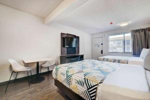 罗克斯普林Studio 6 Rock Springs WY Flaming Gorge的酒店客房配有两张床和一张书桌
