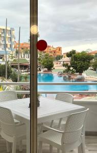 圣米格尔德阿沃纳Dreams vacation tenerife的白色的桌椅,享有游泳池的景色