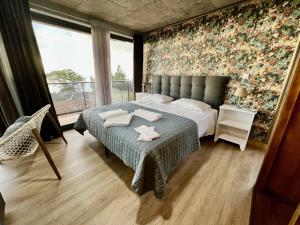 蓬塔杜帕戈Victoria Ocean View Room的一间卧室配有一张带花卉墙壁的床