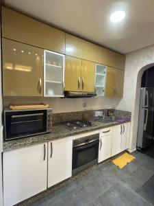 达布阿扎Résidence Galets Sur Mer的厨房配有白色橱柜和不锈钢用具